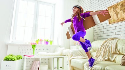 Kind trägt Kartonflügel und Fliegermütze.