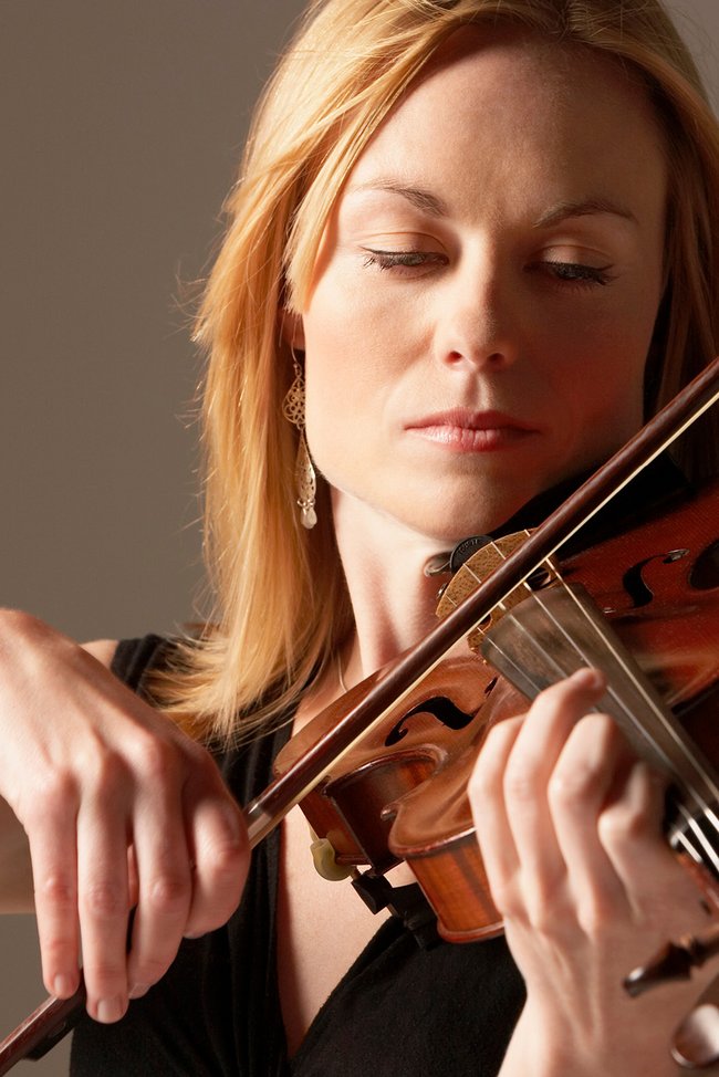 Symbolbild Musikinstrumentenversicherung: Frau spielt Geige