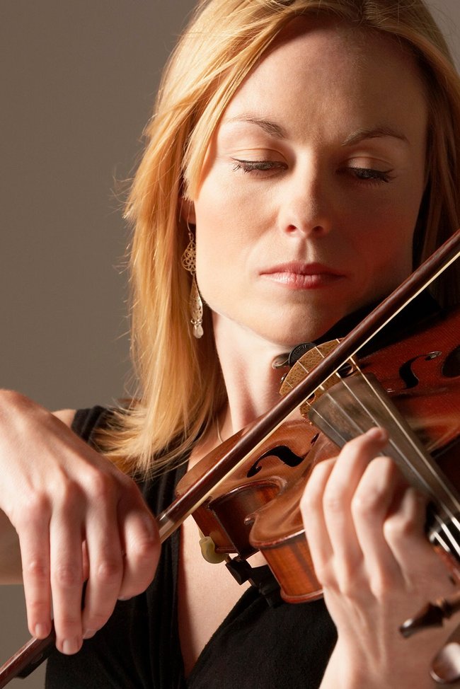 Symbolbild Musikinstrumentenversicherung: Frau spielt Geige