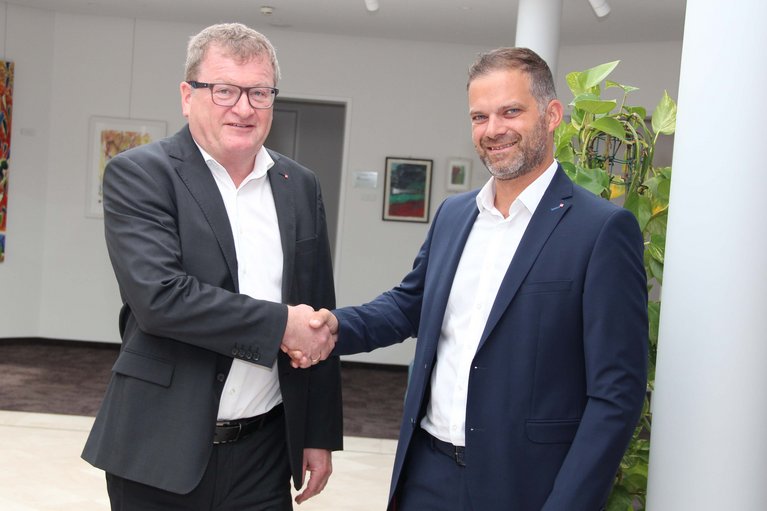 Landeshauptmann Thomas Stelzer und Wirtschaftsminister Martin Kocher geben sich die Hand.