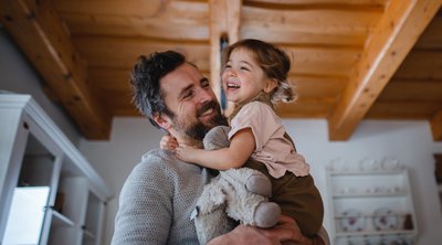 Glücklicher Vater mit Tochter im Arm.