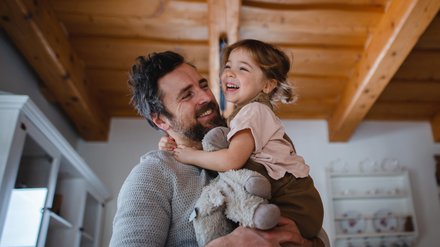 Glücklicher Vater mit Tochter im Arm.