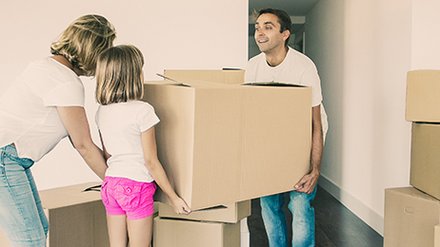 Happy,Parents,And,Girl,Carrying,Box,Into,New,Empty,Flat