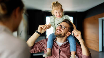 Glücklicher Vater mit Tochter im Arm.