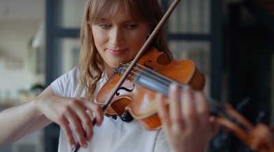 Symbolbild Musikinstrumentenversicherung: Frau spielt Geige.